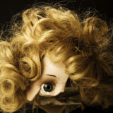 Zerbrochener Puppenkopf mit blondem Haar