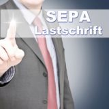 Mann im Anzug wählt auf einem Touchscreen den Button mit der AUfschrift "SEPA Lastschrift" aus