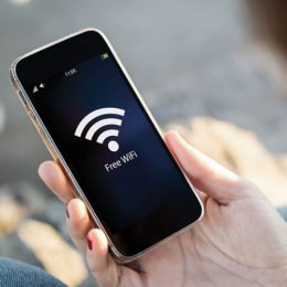 Hand hält ein Smartphone und ist mit freiem WLAN verbunden