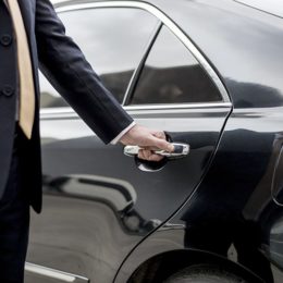 Chaffeur öffnet Tür einer Limousine