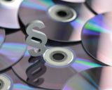 unbeschriftete CDs liegen aufeinander, darauf ein Paragraphensymbol