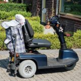 Elektro-Scooter, der für Senioren oder behinderte Personen genutzt werden kann, steht in einer Hofeinfahrt