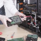 EDV-Mitarbeiter wechselt die Festplatte an einem Computer aus