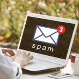 Laptop geöffnet mit Sicht auf Spam-Mail im Posteingang
