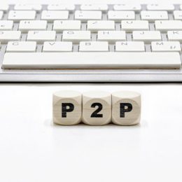 Würfel mit der Aufschrift P2P liegen vor einer Tastatur