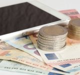 Ein Smartphone und Euro Münzen und Geldscheine