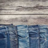 Mehrere Jeans-Hosen auf Holz