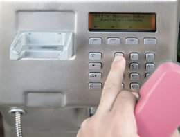 Person wählt eine Nummer am Kreditkartentelefon