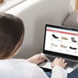 Online-Shopping - Frau mit Laptop auf Sofa