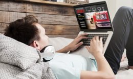 Kind hält Laptop, auf dem ein Streaming-Dienst geöffnet ist
