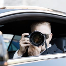 Paparazzi sitzt im Auto und fotografiert