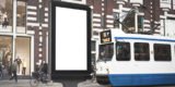 weiße Werbefläche hinter der eine Tram vorbeifährt