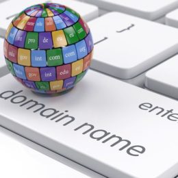 Domain-Name auf Tastatur mit Weltkugel und Domain-Endungen