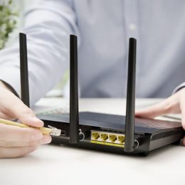 Mann steckt Lan Kabel in Router