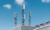 Mobilfunkantennen auf einem Hochhaus mit blauem Himmel