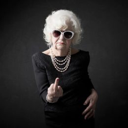 Ältere Frau zeigt MIttelfinger