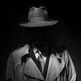 Mafia-Mann mit großem Hut und Mantel in schwarz-weiß