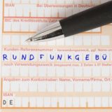 Überweisung für Rundfunkgebühren mit schwarzen Kugelschreiber