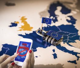 Frau bedient Smartphone ohne Geoblocking-Hürde vor Karte Europas