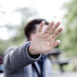 Mann schützt Gesicht mit Hand