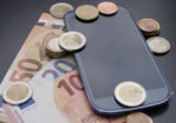 Smartphone mit Geldscheinen und -münzen