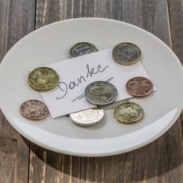 Teller mit Münzen und dem Zettel "Danke"