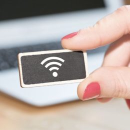 Frau hält einen Chip in der Hand, auf dem ein WLAN-Symbol zu sehen ist.