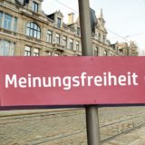 Schild mit der Aufschrift "Meinungsfreiheit" in einer Stadt