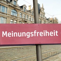 Schild mit der Aufschrift "Meinungsfreiheit" in einer Stadt