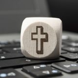 Würfel mit Kreuz auf Tastatur
