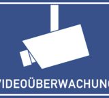 Kamera vor blauem Hintergrund mit dem Schriftzug Videoüberwachung untertitelt
