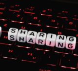 Sharing in Lettern auf einer Laptop-Tastatur