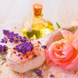 Blumen, Lavendel und Rosen mit Öl in Glasflasche