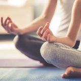 Mutter und Tocher in der Yoga-Position Lotussitz