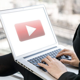 Laptop mit YouTube auf Schoß von Frau