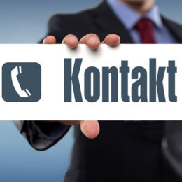 Mann im Anzug hält Schild mit "Kontakt"