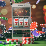 Handy mit Glücksspiel auf dem Bildschirm, daneben fallen Pokerchips herunter