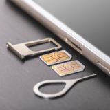 Fotolia_244679402: Smartphone mit zwei SIM-Karten und dem nötigen Zubehör