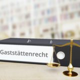 AdobeSOrdner über Gaststättenrecht neben goldener Waage