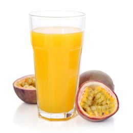 Maracujasaft im Glas und frische Früchte daneben