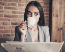 Frau trinkt Kaffee und liest Zeitung