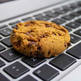 Cookie liegt auf der Tastatur eines Laptops
