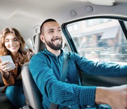 Ein Uberfahrer fährt eine Frau mit Smartphone