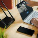 Ein Laptop und ein Smartphone vor einem WLAN-Router