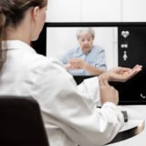 Ärztin erklärt das Blutdruckmessen in einer Online-Behandlung