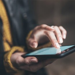 Eine Frau tippt auf einem Smartphone