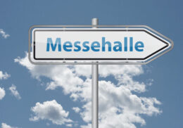 "Messehalle" vor einem Wolkenhintergrund