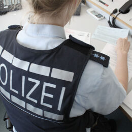 Polizistin in Uniform sitzt am Schreibtisch
