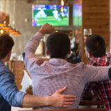 Männer schauen in einer Kneipe Fußball