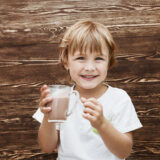 Kind mit Tasse mit Kakao in der Hand